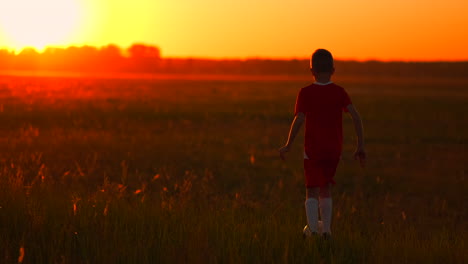 Ein-Actionsportbild-Einer-Gruppe-Von-Kindern,-Die-Vor-Sonnenuntergang-Fußball-Spielen,-Um-Sich-Zu-Bewegen